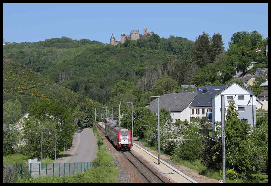 Vor der im Hintergrund empor ragenden Burg Bourscheid nähert sich hier am 24.5.2023 der CFL ET 16 nach Louxembourg Gare dem Haltepunkt Michelau.