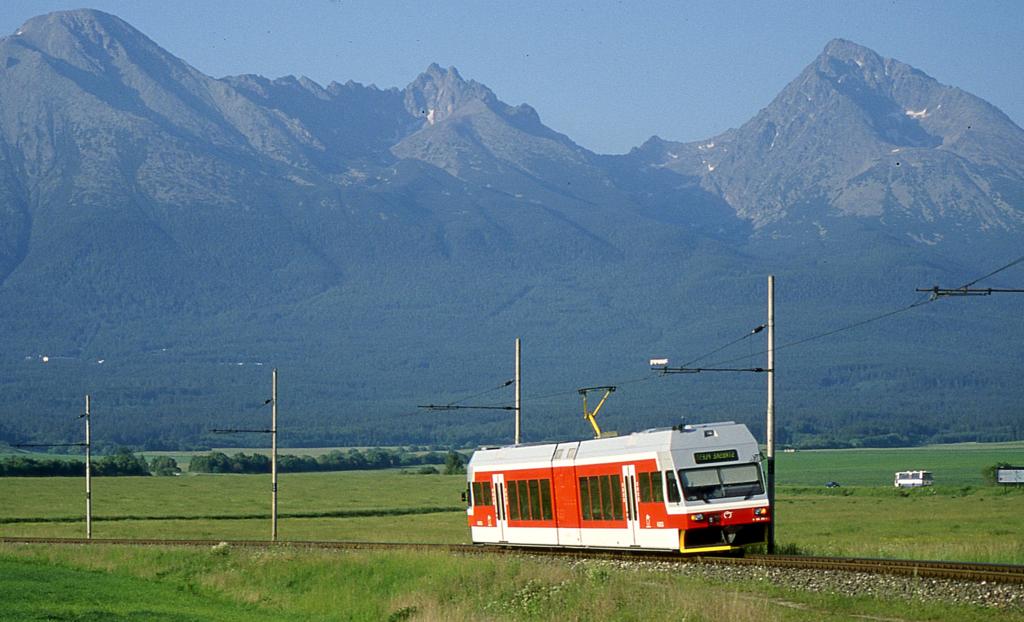 Vor der imposanten Bergkulisse der Hohen Tatra fhrt ein moderner Elektro
Triebwagen als Zug 8106 nach Strbske Pleso in die Berge hinein.