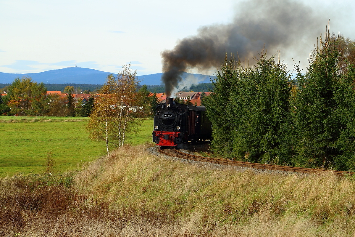 Vor der Kulisse des Brockenmassivs und der Stadt Hasselfelde, präsentiert sich hier 99 6101 am 18.10.2014, mit einem IG HSB-Sonderzug bei einer Scheinanfahrt, kurz hinter Hasselfelde. (Bild 1)