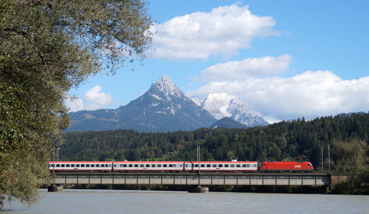 Vor der Kulisse des leicht angezuckerten Zahmen Kaisers zieht eine 1216 den EC 89  DB-ÖBB EuroCity  (München Hbf - Bologna Centrale) bei Kirchbichl über den Inn und weiter in Richtung Wörgl, 25.09.2018.
