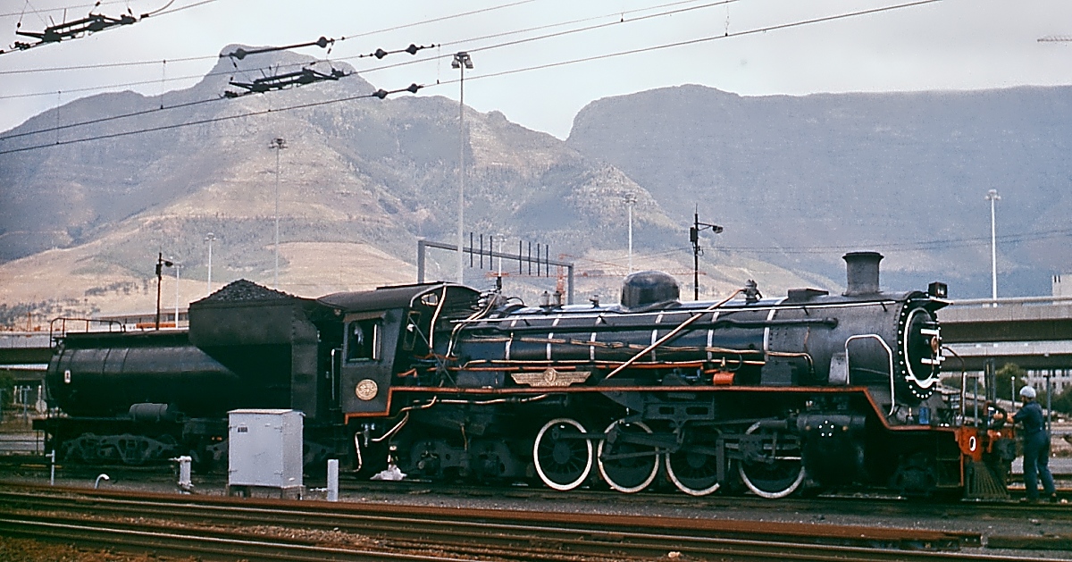 Vor der Kulisse des Tafelberges wartet eine Class 24 im November 1976 im Hafen von Kapstadt auf neue Aufgaben, Leider wollte sich die gut gepflegte Lok nicht bewegen und so blieb mir nichts anderes übrig, als sie mit dem hässlichen Kasten vor dem Tender aufzunehmen.