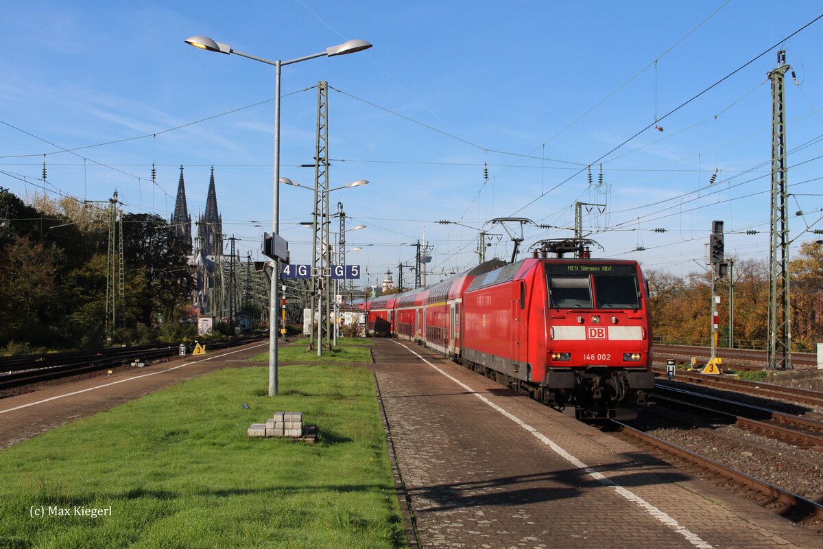 Vor der Kulisse der Hohenzollernbrücke und dem Kölner Dom fährt die 146 002 mit dem RE9 10911 in Richtung Siegen Hbf in den Bahnhof Köln Messe/Deutz.
