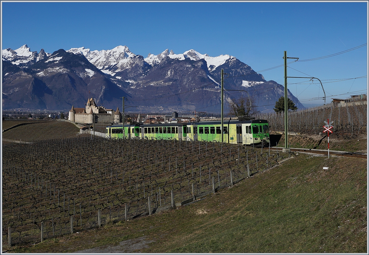 Vor der Kulisse der Walliser Alpen und des Château de Aigle fährt der ASD Regionalzug 432 oberhalb von Aigle Richtung Les Diablerets.
Wintersportfrequenz bedingt wird der Zug, bestehend aus dem BDe 4/4 403 und Bt 432, durch den am Schluss laufenden BDe 4/4 404 verstärkt. Auffallend dabei, die etwas abweichende, aber gefällig die Lackierung des BDe 4/4 404 mit dem schwarzen Fensterband.

17. Februar 2019