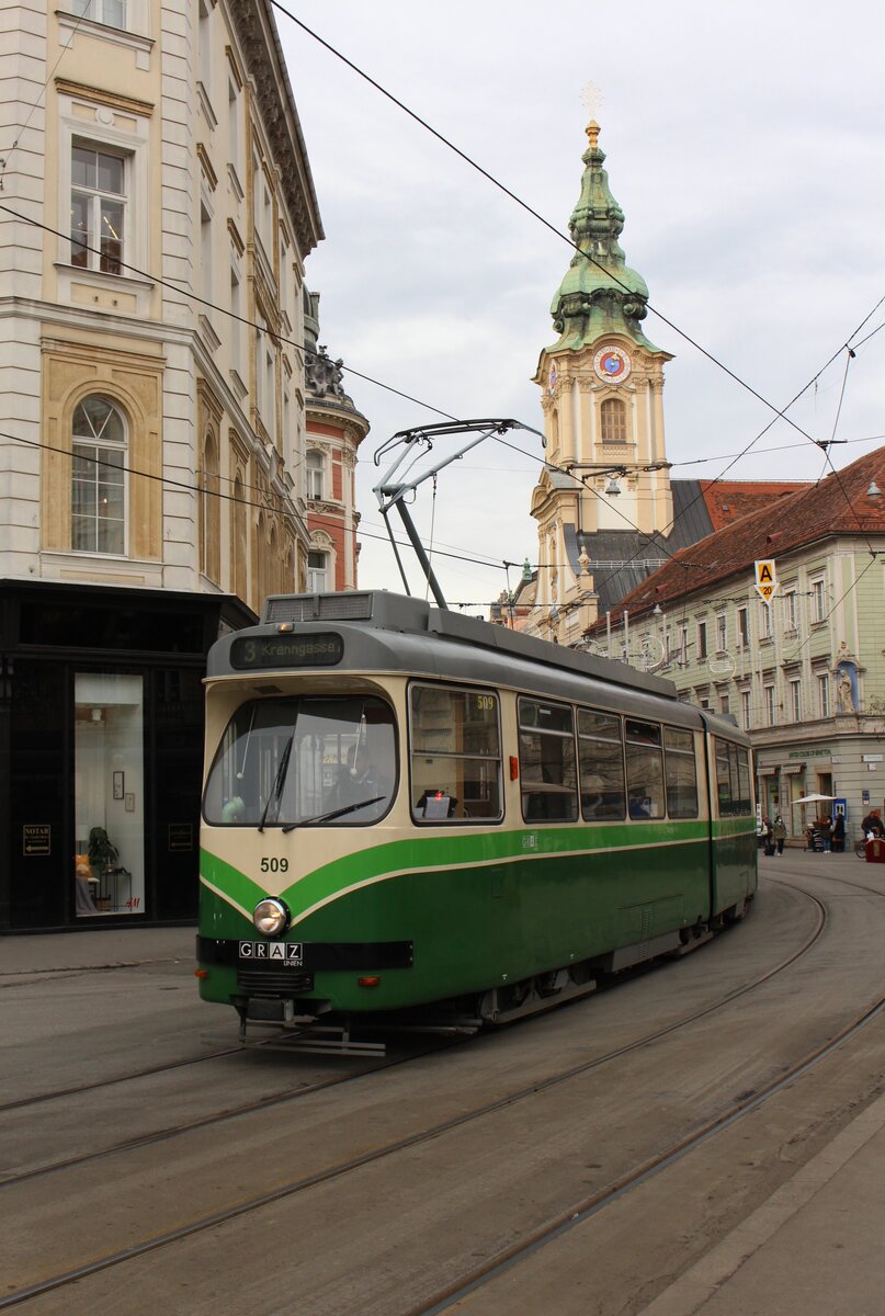 Vor der römisch-katolischen Stattpfarrkirche von Graz aus dem 16. Jahrhundert fährt am 4.1.2022 der Wagen 509 von Andritz kommend durch die Herrengasse in Richtung Krenngasse.