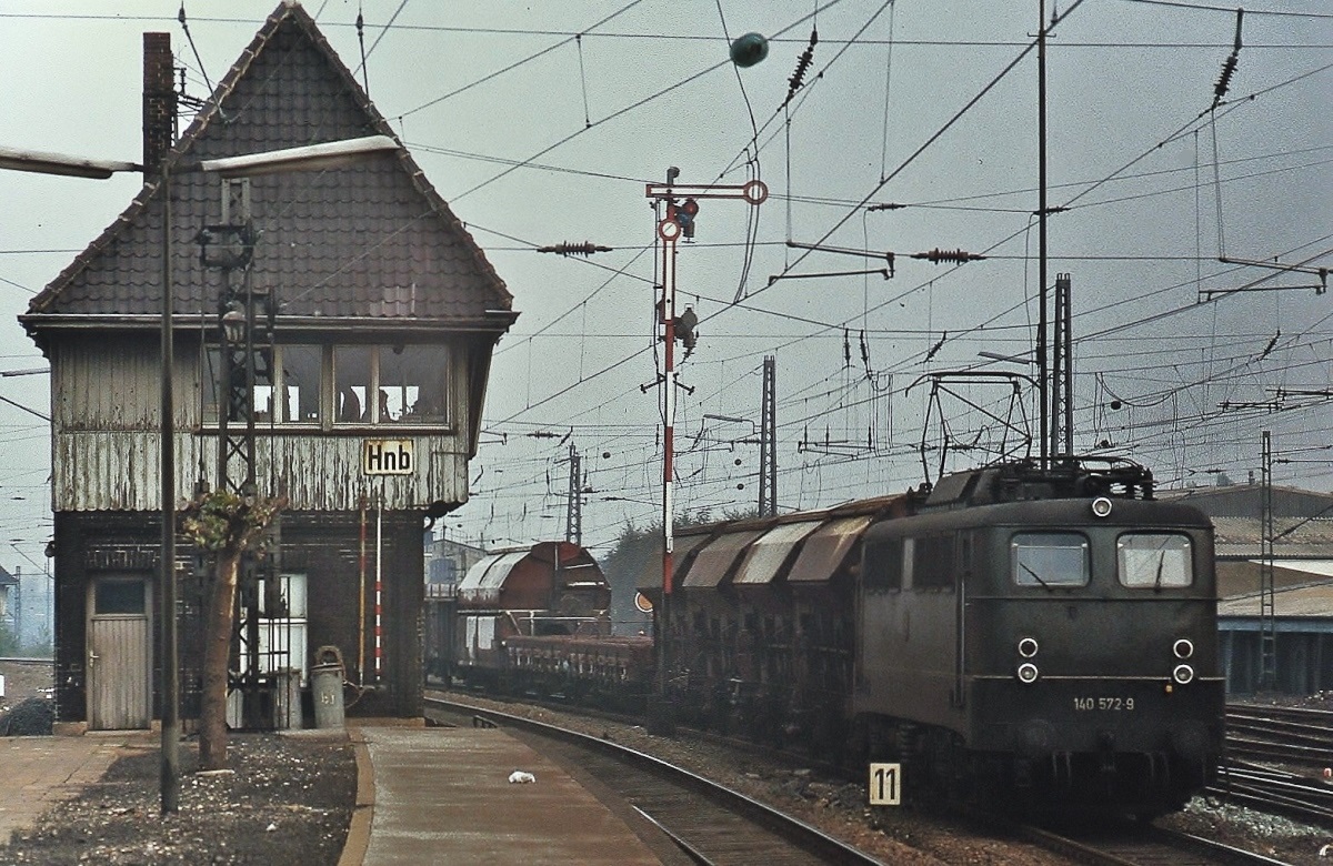 Vorbei am 1982 abgerissenen Stellwerk Hnb schleppt 140 572-9 einen gemischten Güterzug durch den Bahnhof Herne (Winter 1979)