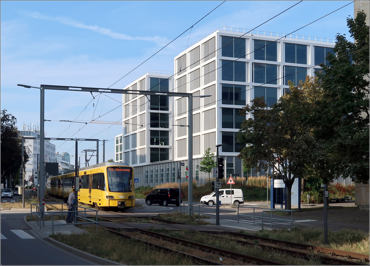 Vorbei am Daimler Office V - 

... in Stuttgart-Vaihingen ist eine Langzug auf der U12 in Fahrtrichtung Dürrlewang. Jeweils an den Kreisverkehren finden sich diese torartigen Oberleitungsbrücken an diesem noch rechten neuen Streckenabschnitt vom Wallgraben nach Dürrlewang.

30.08.2022 (M)