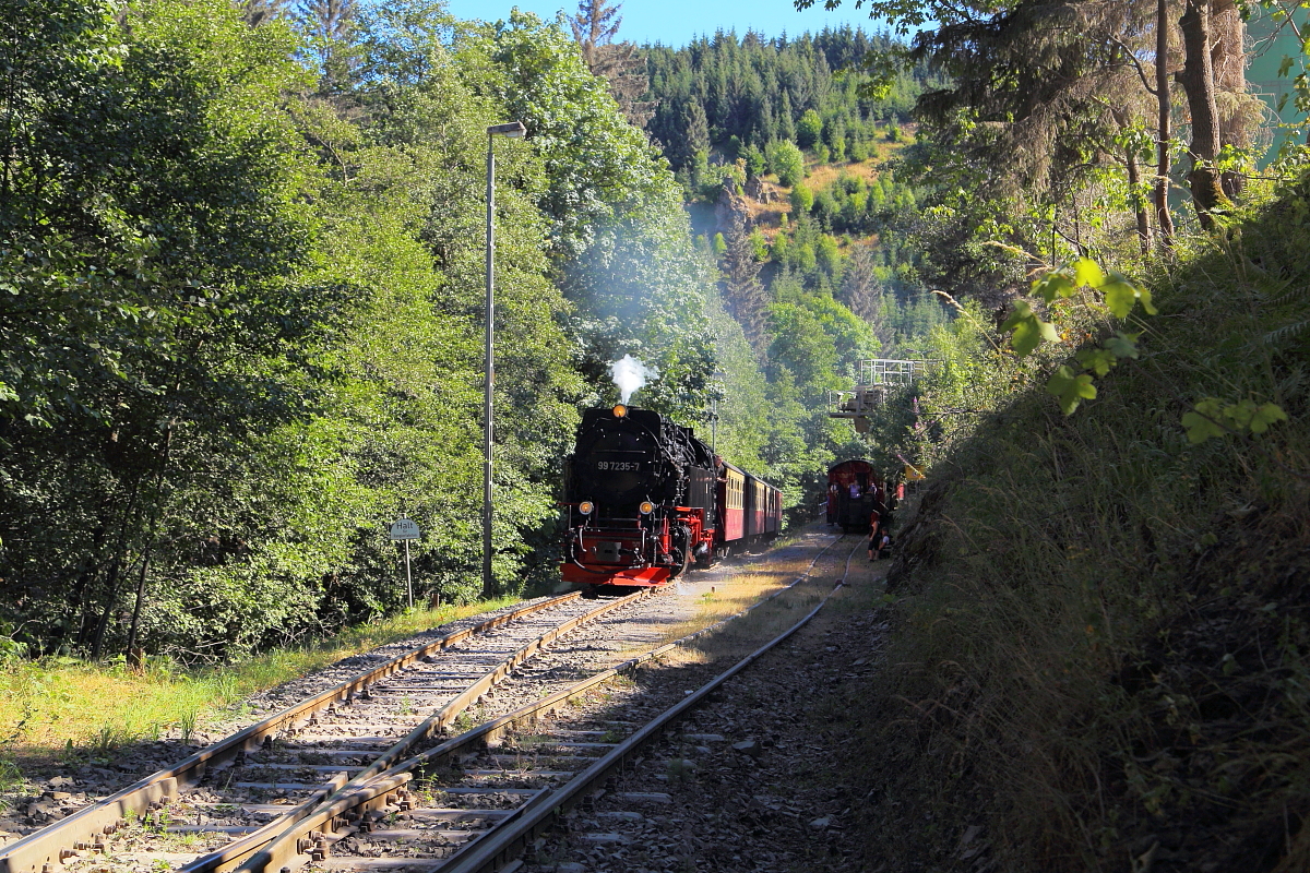 Vorbeifahrt von 99 7235 mit P8964 (Eisfelder Talmühle - Quedlinburg) am 07.07.2018 am Unterberger Steinbruch. (Bild 1) Auf dem Anschlußgleis des Steinbruches wartet derweil 99 5906 mit einem Sonderzug auf die Weiterfahrt.