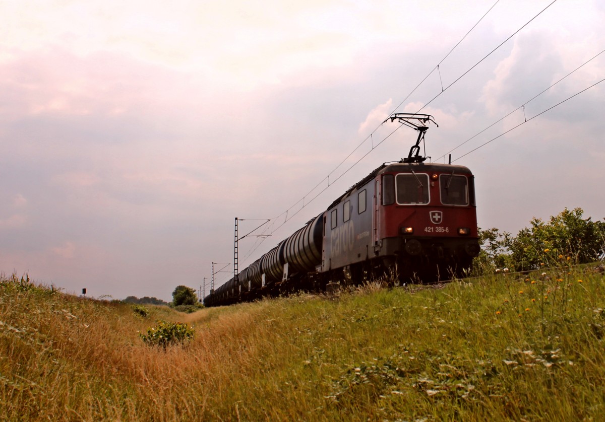 Vorbeifahrt am 28.08.2013 von der SBB Cargo Re 421 385-6 mit einem langem leeren Kesselwagenzug bei Hügelheim, nördlich von Müllheim (Baden) gen Freiburg (Breisgau).