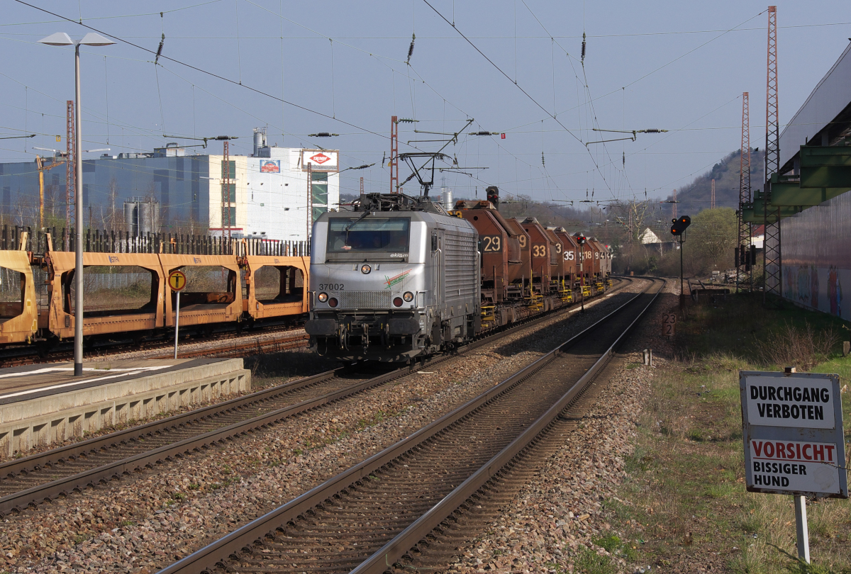 Vorne fährt die  Suppe  und Hinten gibt es Schokolade - Akiem 37002 (Marathon Lok) bringt die leeren Torpedowagen aus Völklingen nach Dillingen/Hochofen zurück. Vor der Durchfahrt in Saarlouis Hbf. hat der Zug das Trumpf Schokoladenwerk passiert. 
Bahnstrecke 3230 Saarbrücken - Karthaus am 08.04.2015