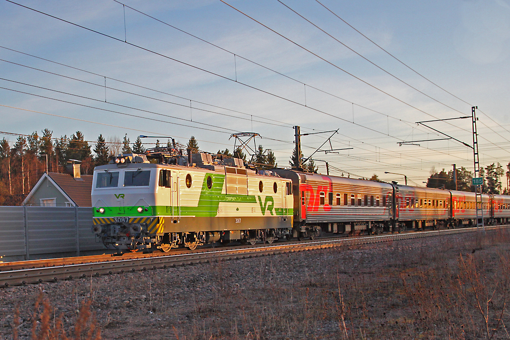 VR Sr1 3087 frischlackiert und in voller Fahrt,im letzten Tageslicht hat den P31  Tolstoy  Nachtzug Helsinki-Moskau am Haken und passiert gerade den Bahnhof Koria.das Bild entstand am 10.4.2014