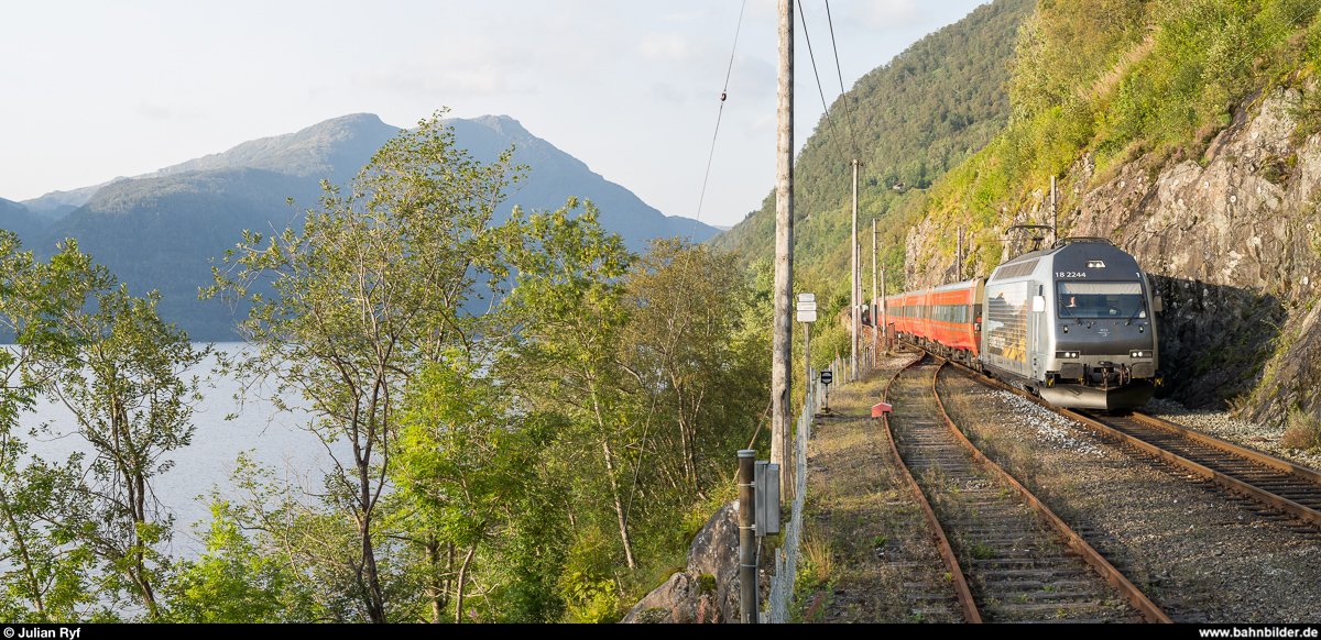 Vy El 18 2244 als Regiontog Oslo - Bergen am 25. August 2019 in Trengereid. <br>
Nur dank einer Verspätung von 20 Minuten und der Verlegung der Kreuzung dieses Zuges mit dem Lokaltog Bergen - Voss von Arna nach Trengereid konnte dieses Bild so umgesetzt werden. Das ausserhalb des Tunnels liegende Gleis 2 des Bahnhofs Trengereid wird nur bei Kreuzungen befahren. Das Gleis ist ein Überbleibsel des alten Trasses vor dem Bau des 6'096 m langen Hananipa-Tunnels.