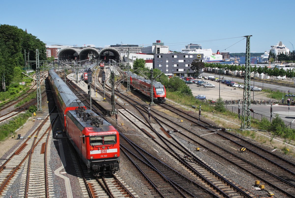 Während 112 163 mit dem RE70 (RE21017) nach Hamburg Hauptbahnhof Ausfahrt hat, erreicht der RE83 (RE21610) mit 648 855-4  Fehmarn  und 648 338-1  Lauenburg/Elbe  aus Lübeck Hauptbahnhof den Endbahnhof Kiel. (11.6.2016)