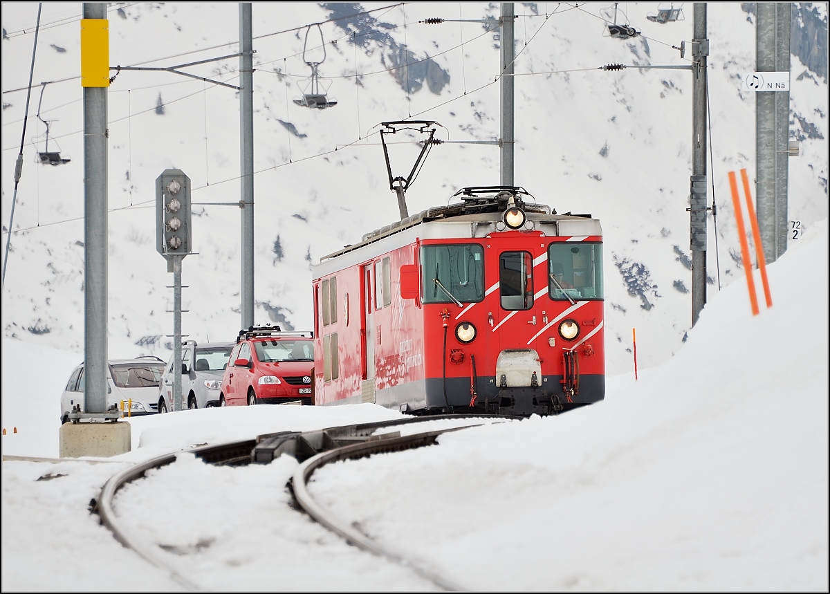 Während 1300 m tiefer im Gotthardtunnel neuerdings mit 200 Sachen geheizt wird, geht das Leben oben auf dem Berg unverändert in einer völlig anderen Geschwindigkeit weiter. 9 Minuten für Luftlinie 1,5 km Luftlinie, wenn man den Höhenunterschied mittels Pythargorassatz einrechnet, das langt gerade mal für 10 km/h. Deh 4/4 23  Randa  mit einem Autotransportzug auf den letzten Metern nach Nätschen. März 2012.