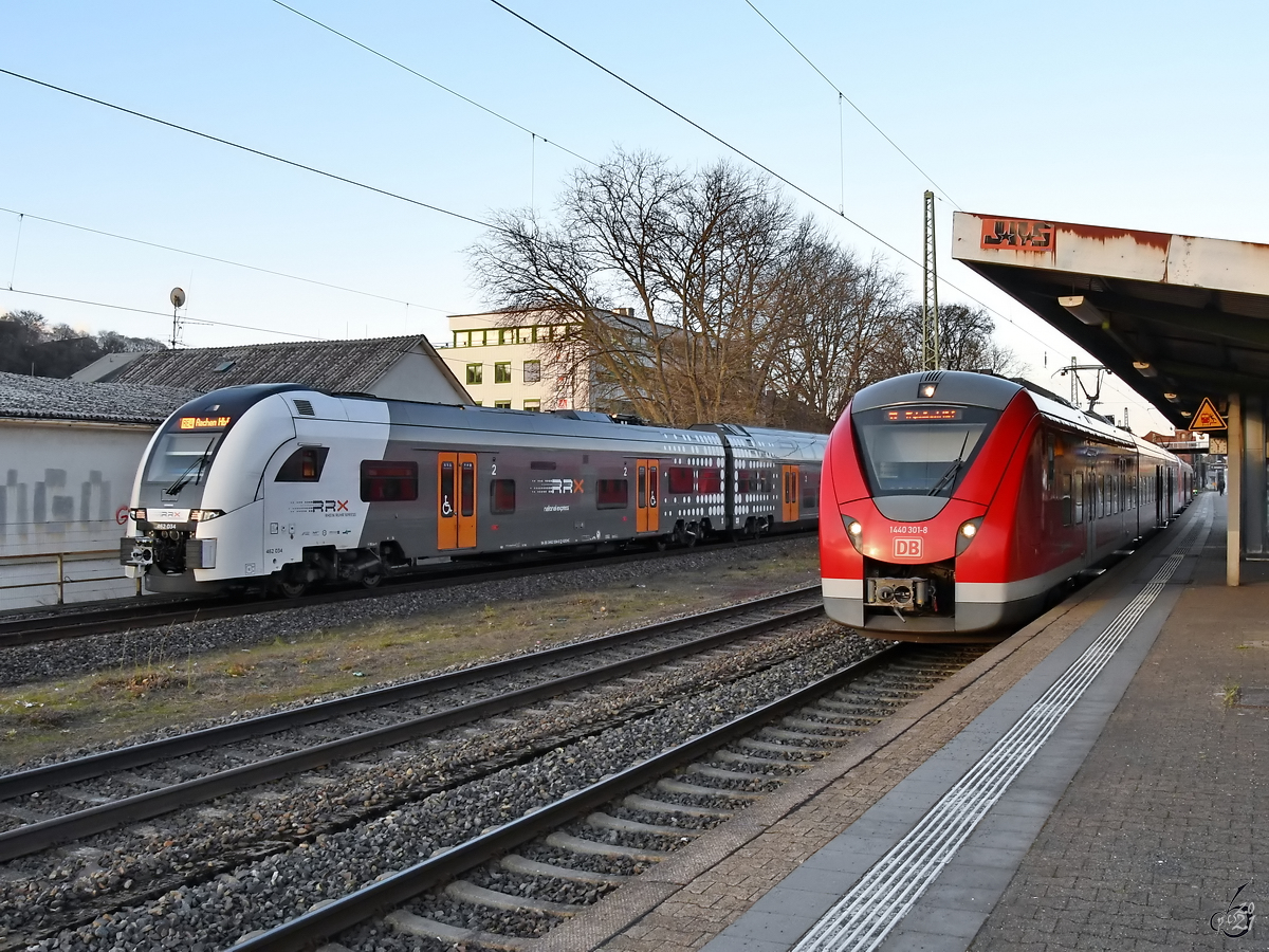 Während 1440 301-8 (S8 nach Mönchengladbach Hbf) gerade neue Fahrgäste in Wuppertal-Unterbarmen aufgenommen hat ist 462 034 (RE4 nach Aachen Hbf) bei der Durchfahrt zu sehen. (März 2021)