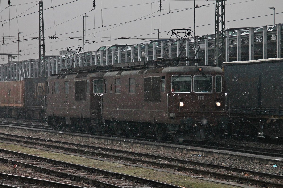 Während 185 536-0 mit ihren Zug über Gleis 1 fuhr, musste am 19.01.2016 die Re 4/4 170 (425 170-8)  Brig-Glis  zusammen mit Re 4/4 174 (425 174-0)  Frutigen  bei leichtem Schneefall warten, bis sie über Gleis 1 n Richtzung Abstellgleis im nördlichen Vorfeld von Basel Bad Bf fahren konnten.