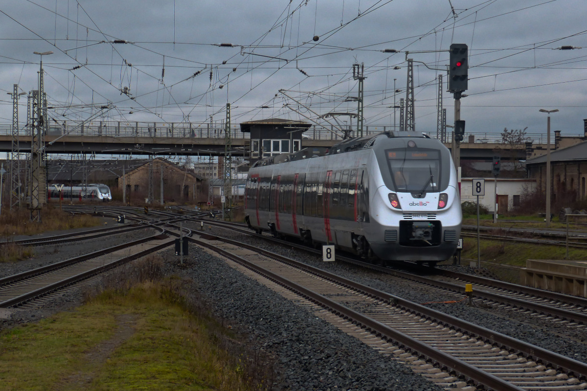 Während Abellio 442 603 den Bahnhof Nordhausen als Regionalbahn nach Leinefelde verlässt, wartet ein weiteres Fahrzeug vor dem alten Lokschuppen auf seinen nächsten Einsatz. 22.12.2015