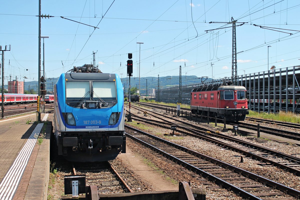 Während am 24.06.2015 die Re 6/6 11652  Kerzers  auf mehrere Zugkreuzungen wartet, um nach Basel Bad Rbf/Weil am Rhein zu fahren, stand Bombadier 187 003-9  Hans-Werner  südlich von Bahnsteig 2/3 in Basel Bad Bf abgestellt und wartete auf ihre Überführung zu BLS Cargo nach Speiz für Messfahrten.