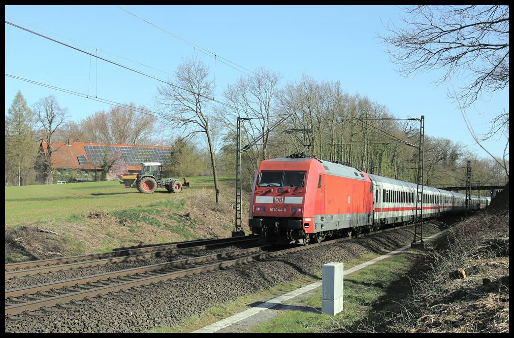 Während auf dem benachbarten Feld ein Bauer in Hasbergen mit Hilfe seines Traktors Dünger ausbringt, passiert ihn DB 101044-6 mit einem Intercity. Die Lok schiebt den IC um 9.32 Uhr am 1.4.2019 über die Rollbahn in Richtung Osnabrück.