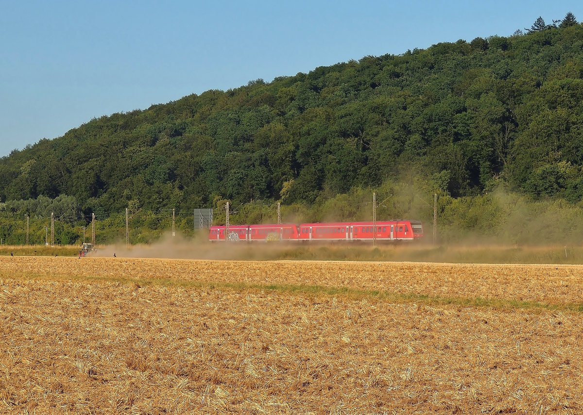  Während der Bauer mit sein Feld bestellt, der Interregio von Tübingen nach Stuttgart schnellt 
Aufnahme vom 22.07.2015 im Neckartal bei Lustnau.