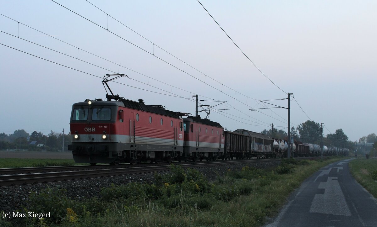 Während bei der Abfahrt in Graz Vbf noch die Sonne schien, so herrschte im niederösterreichischen Industrieviertel bereits eine düstere Herbststimmung.
Die 1144 123 und 1144 225 warten hier am 13.10.2022 in Ebenfurth mit dem DG55072 von Graz Vbf nach Wien Zvb auf die Weiterfahrt.