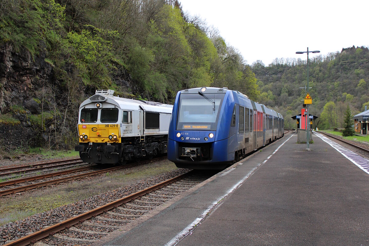Während ECR 266 429-0 mit ihrem Militärzug aus Baumholder auf Ausfahrt Richtung Neunkirchen(Saar) wartet, dieselt 622 436 der vlexx als RB34 von Idar-Oberstein nach Baumholder durch den Bahnhof Heimbach(Nahe). (29.04.2023)