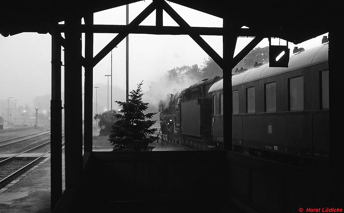 Whrend eines heftigen Gewitters ist 01 1100 mit einem Sonderzug im Bahnhof Neukirchen bei Sulzbach-Rosenberg eingetroffen (Juli 1985). An der Tanne in der Bildmitte ist sichtbar, wie strmisch der Wind blies.