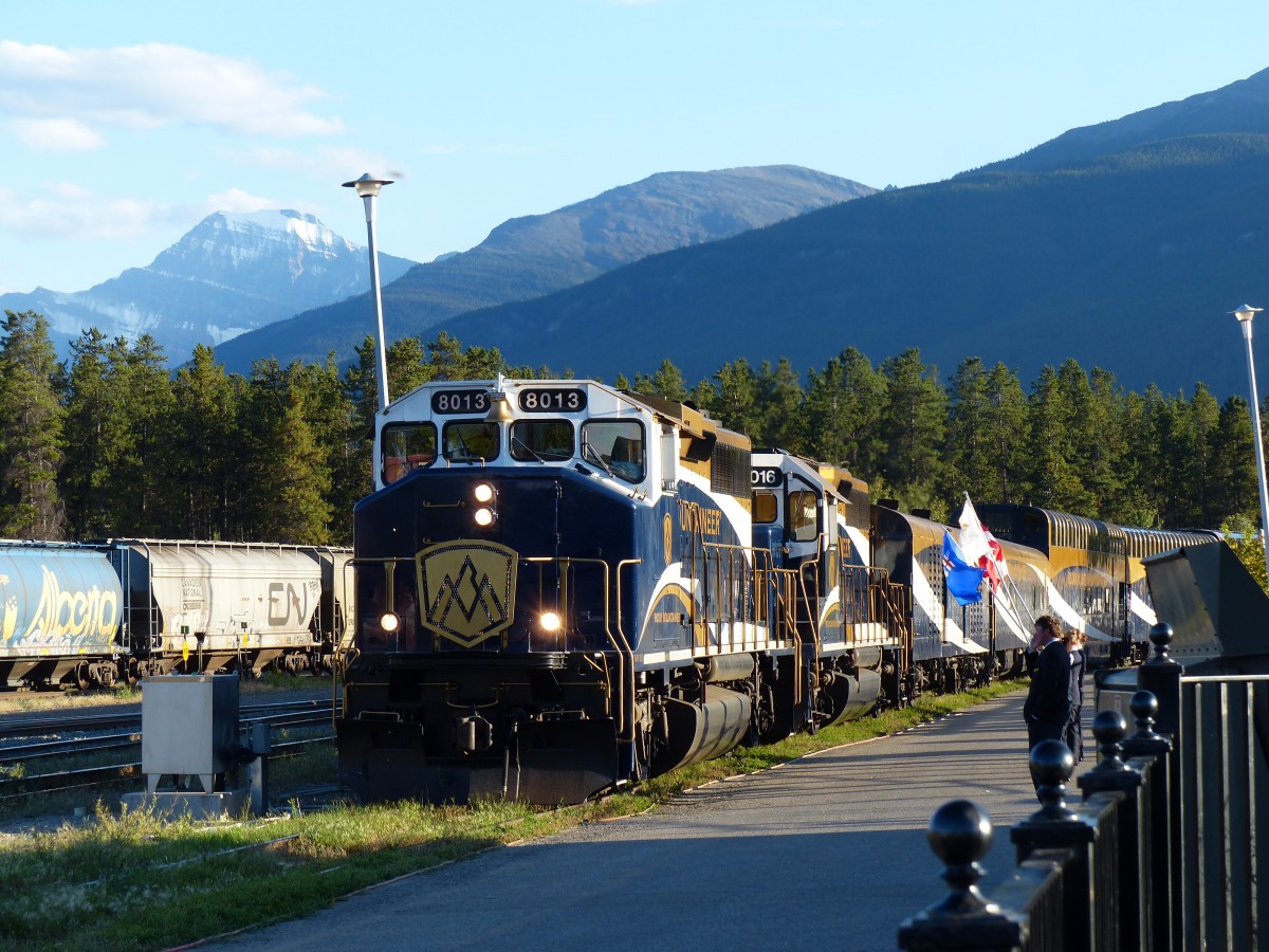 Whrend einige Angestellte Flaggen schwenken fhrt am 05.09.2013 der Rocky Mountaineer gezogen von Lok 8013 und 8016 nach der zweitgigen Fahrt aus Vancouver in den Bahnhof Jasper ein.
