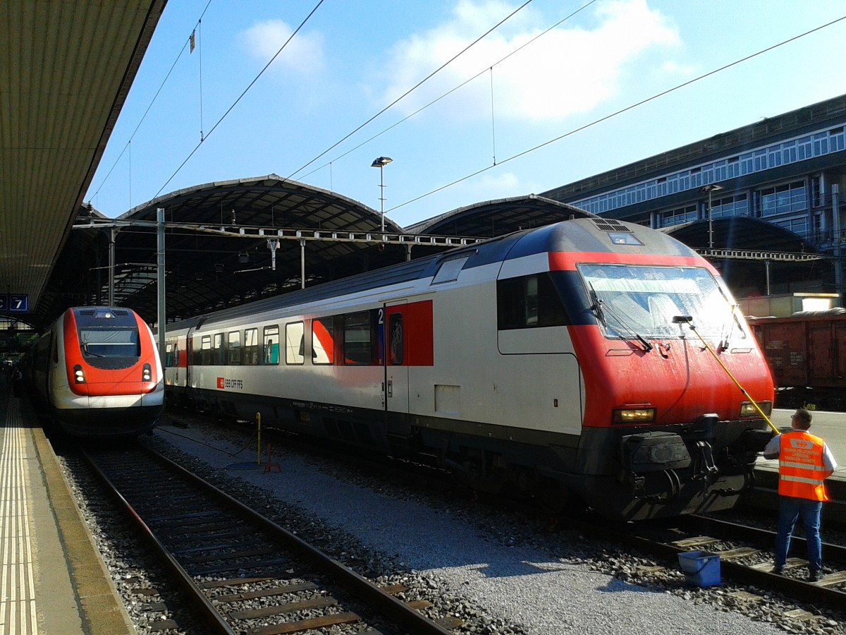 Während die Fahrgäste ausstiegen wurde die Zeit noch schnell genutzt um beim Steuerwagen des IR 2463 von Basel SBB die Frontscheiben zu reinigen, danach ging es für die Garnitur auf ein Abstellgleis. Hinten links zu sehen ist RABDe 500 020-3 als ICN 668 (Chiasso - Bellinzona - Luzern - Olten - Basel SBB). Aufgenommen am 24.7.2015 im Bahnhof Luzern.