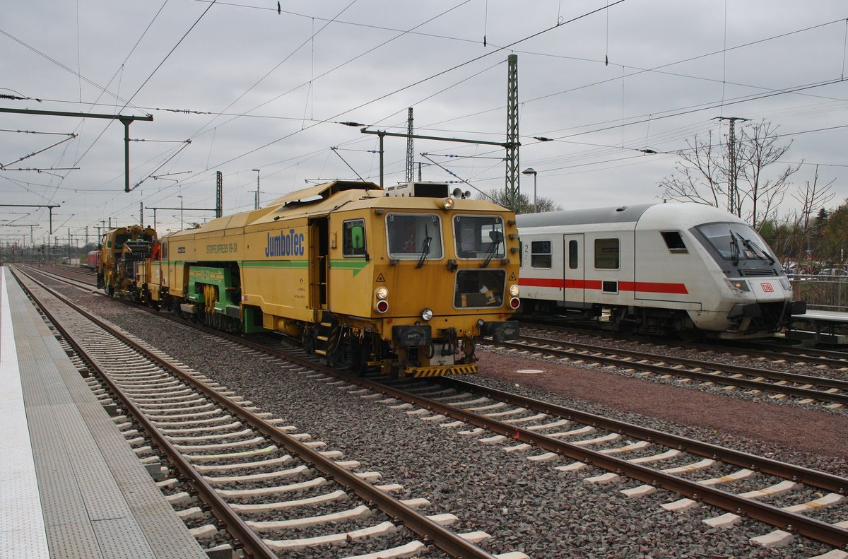 Während der IC1933 von Oldenburg(Oldb) nach Leipzig Hauptbahnhof mit 101 034-7 auf Abfahrt wartet, durchfährt eine Stopfmaschine zusammen mit einem Schotterpflug den Magdeburger Hauptbahnhof. (7.4.2017)