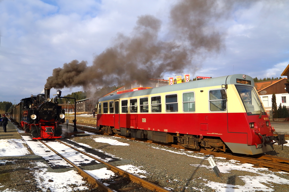 Während die Lok des IG HSB-Sonderzuges am Vormittag des 26.02.2017 im Bahnhof Benneckenstein Wasser nimmt, fährt Triebwagen 187 017 als P 8902 (Eisfelder Talmühle - Wernigerode) ein.