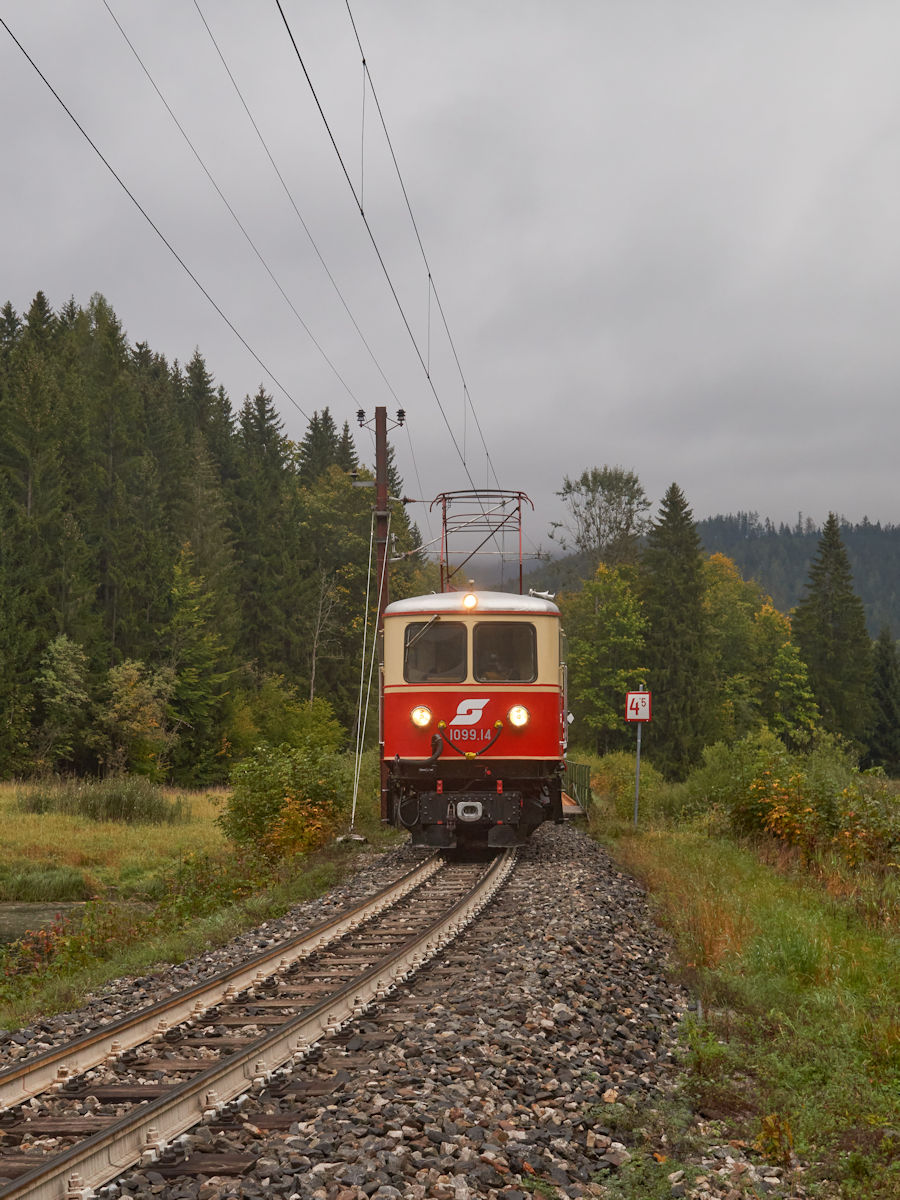 Während der morgendliche Nebel über dem Stausee Wienerbruck aufsteigt, ist NÖVOG E14 (als ÖBB 1099.014) mit ihrem Personenzug in Richtung Mariazell unterwegs. (Fotohalt bei Sonderfahrt am 29.09.2021)