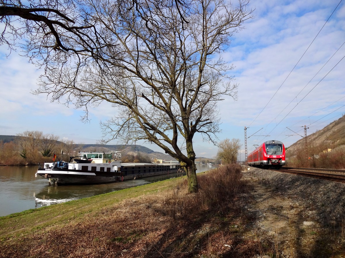 Während das Schiff  Isabell  auf weiterfahrt wartete, schoss ein 440 aus Jossa dem Bahnhof Würzburg entgegen. 
Aufgenommen bei Thüngersheim. 