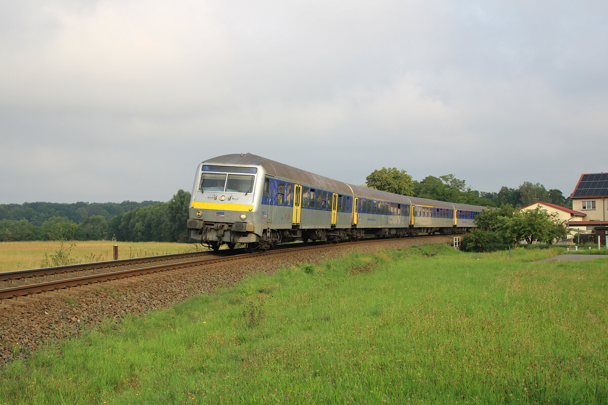 Während sich die ersten Sonnenstrahlen langsam durch die dichte Wolkendecke am Morgen kämpfen, rollt ein RE6 durch den Ort Lauterbach-Steinbach auf seinem Weg von Leipzig Hbf nach Chemnitz Hbf. (20.08.2023)