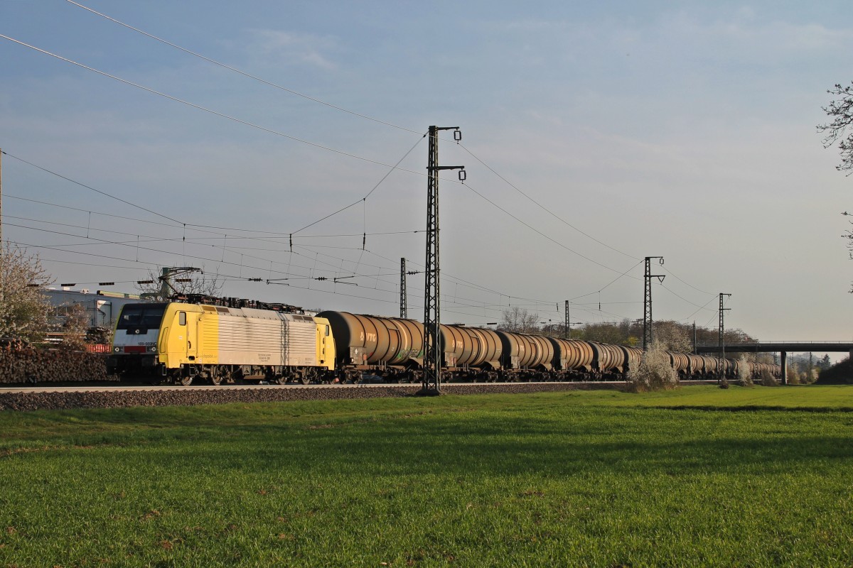 Während die Sonne am 29.03.2014 über dem Ort Auggen unterging, fuhr die MRCE/HTRS Nederland 189-989NC (ES 64 F4-089) mit einem Kesselzug an der Firma Jacoby in Richtung Norden unbeeindrückt vorbei.