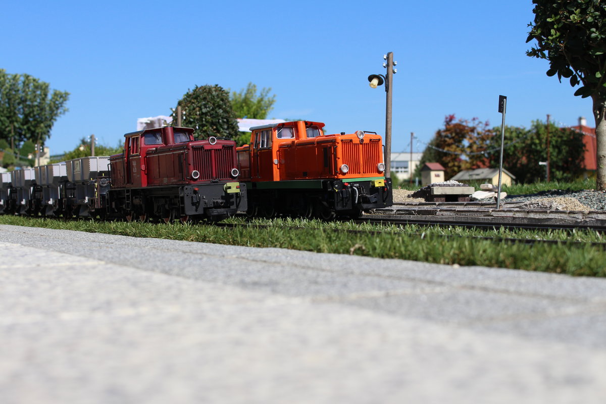 Während der Triebfahrzeugführer der VL21 mit dem leeren Schotterzug (links) im Bahnhof Trassdorf ein  Kaltgetränk  in der Fahrdienstleitung trinkt, durchfährt am 5.9.2020 die StLB VL22 (rechts) den Bahnhof mit einem Sammler in Richtung Fassl.