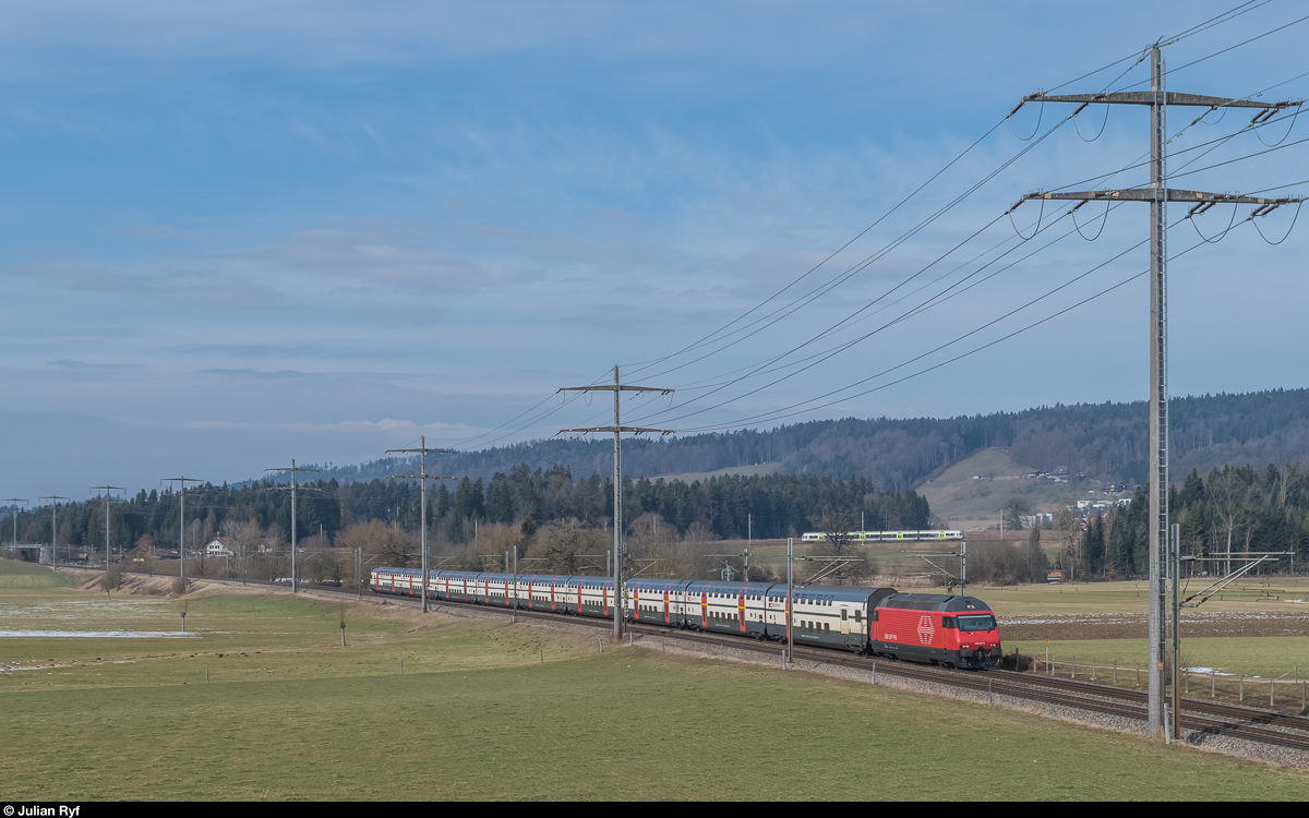 Während vorne ein IC 2000 in Richtung Thun eilt, fährt hinten ein Lötschberger als RE aus Luzern in Richtung Bern. Allmendingen, 11. Februar 2017.