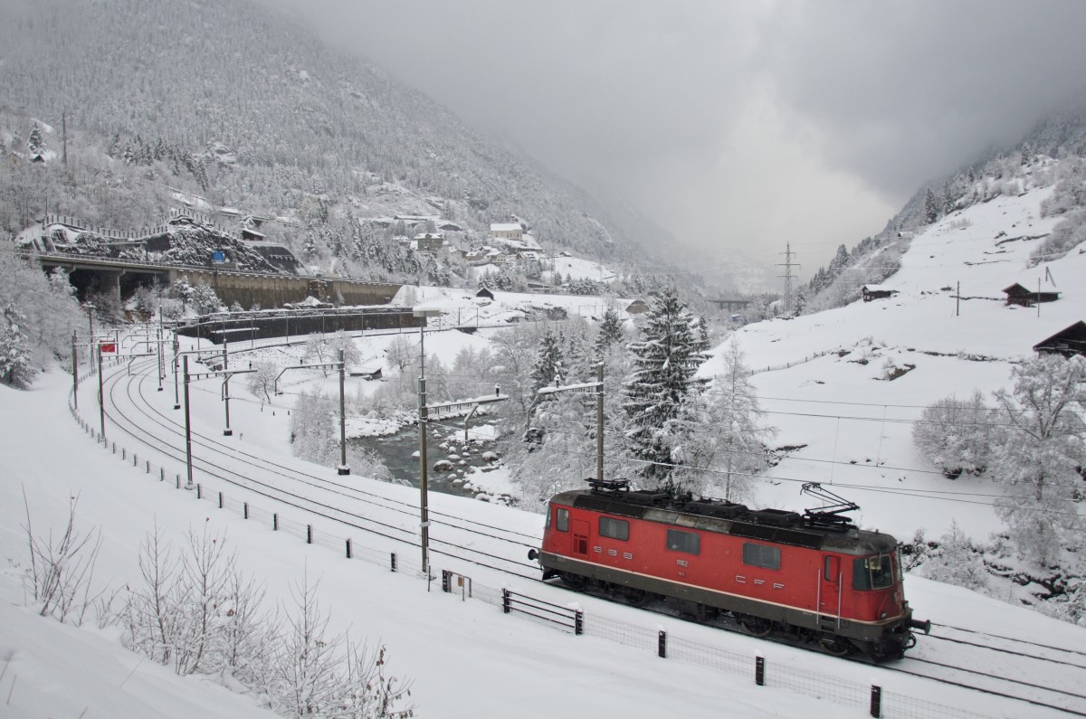 Währenddessen die nächsten Schneewolken aufziehen ist die Re 4/4 II 11162 nach getaner Schiebedienstleistung unterwegs zurück nach Erstfeld, um bald darauf dem nächsten Güterzug Unterstützung hinauf nach Göschenen geben zu können. 26.11.2015