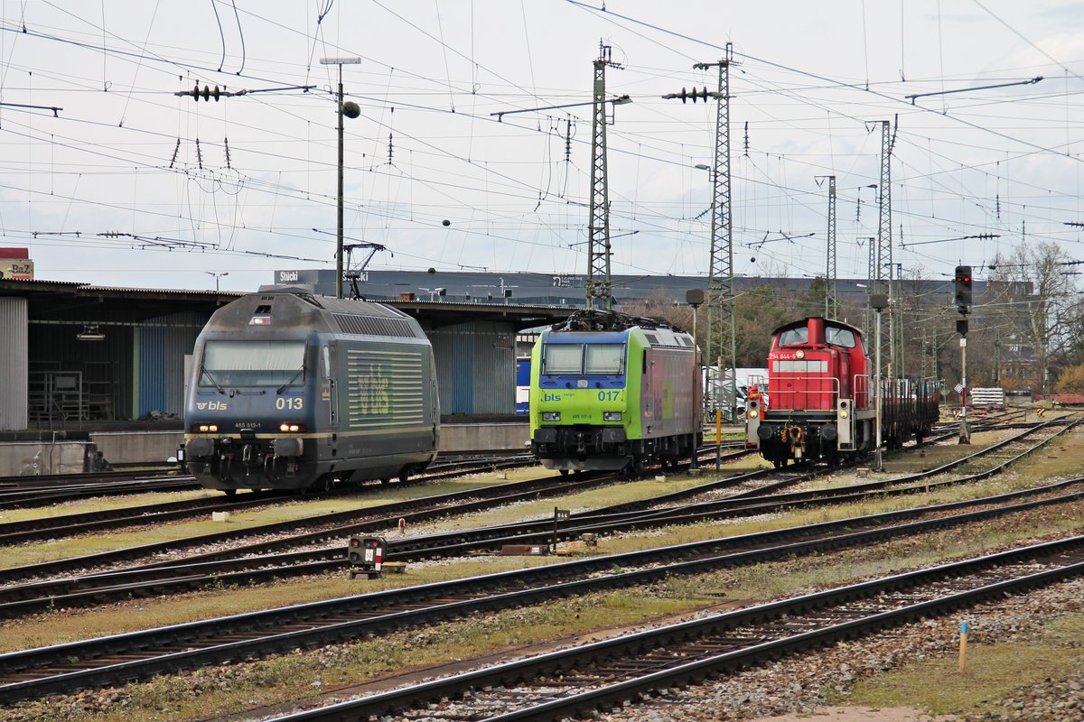 Wärend am 29.03.2016 die Re 485 017-8 abgestellt im nördlichen Vorfeld vom Badischen Bahnhof von Basel stand, machte sich links von ihr die Re 465 013-1  Stockhorn  startklar und rechts kam 294 844-6 mit zwei Flachwagen aus Basel Bad Rbf an.