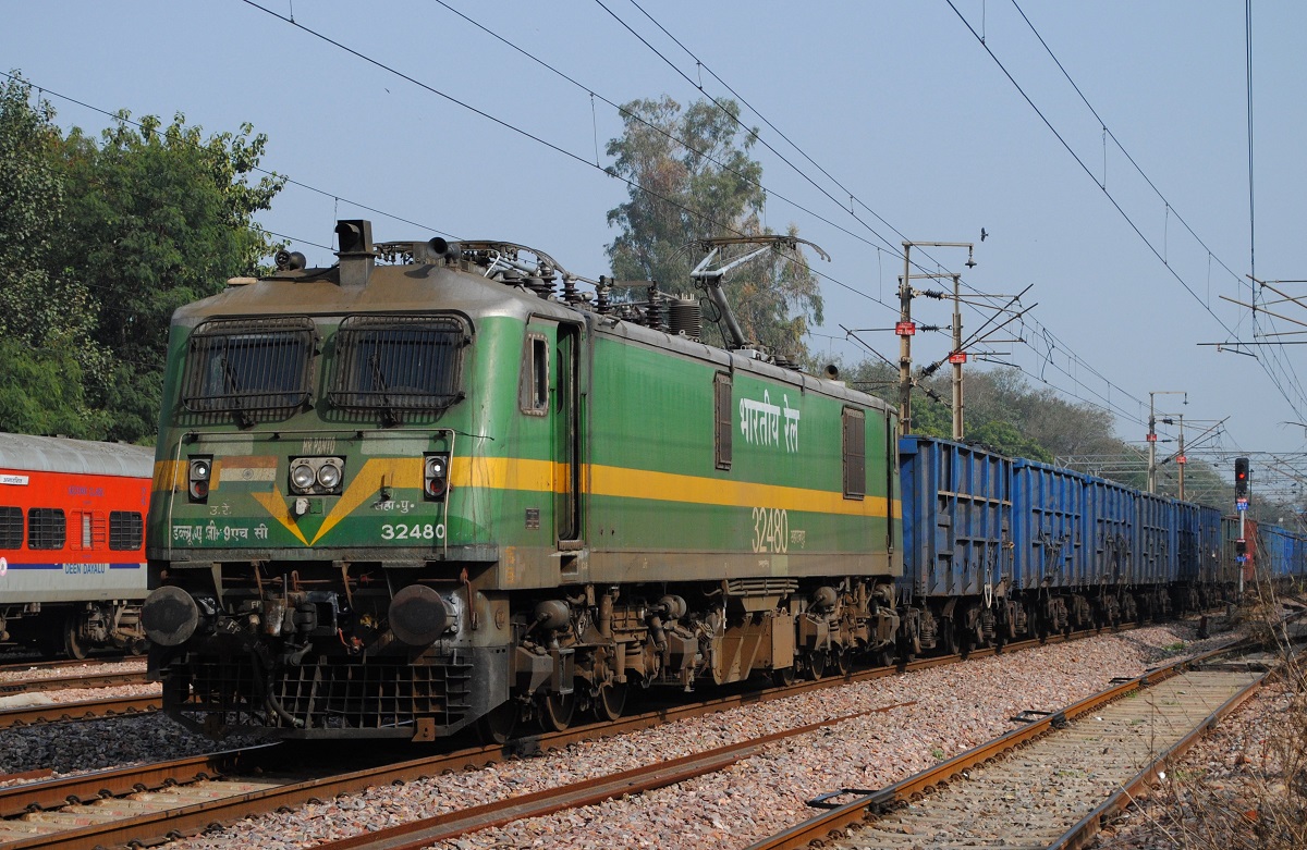 WAG-9 32480 mit Güterzug bei der Durchfahrt durch Delhi - Safdarjung. Die über dem Mittelscheinwerfer erkennbare Bezeichnung  HR PANTO  (= High Reach Pantograph) weist darauf hin, dass die Lok mit Stromabnehmern für eine grössere Fahrleitungshöhe von bis zu 7,87m (normal max. 6,5m) über Schienenoberkante ausgestattet ist. (05.02.2024)