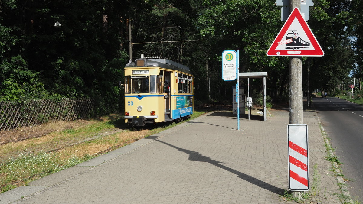 Wagen 30 der Woltersdorfer Straßenbahn GmbH (linie 87 im VBB) wartet auf Fahrgäste, um vom S-Bahnhof Rahnsdorf nach Woltersdorf zu fahren.

Gewarnt wird vor einer Eisenbahn, tatsächlich wird  nur  die Straßenbahn gequert, daher auch kurz vor der Kurve das Überholverbot.

Berlin Rahnsdorf, der 23.08.2020