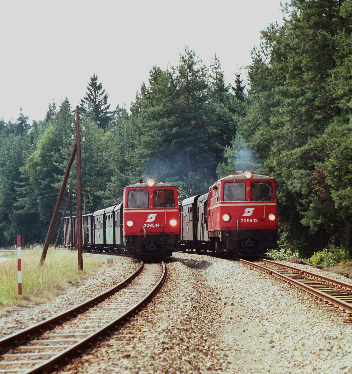 Waldviertelbahn zu ÖBB-Zeiten (Nordast): ÖBB-Lokomotiven 2095.14 und 2095.12 bei der unvergleichlichen Parallelausfahrt von Alt-Nagelberg. Fahrtziele der kleinen Züge sind Litschau und Heidenreichstein.
Datum: 20.08.1984