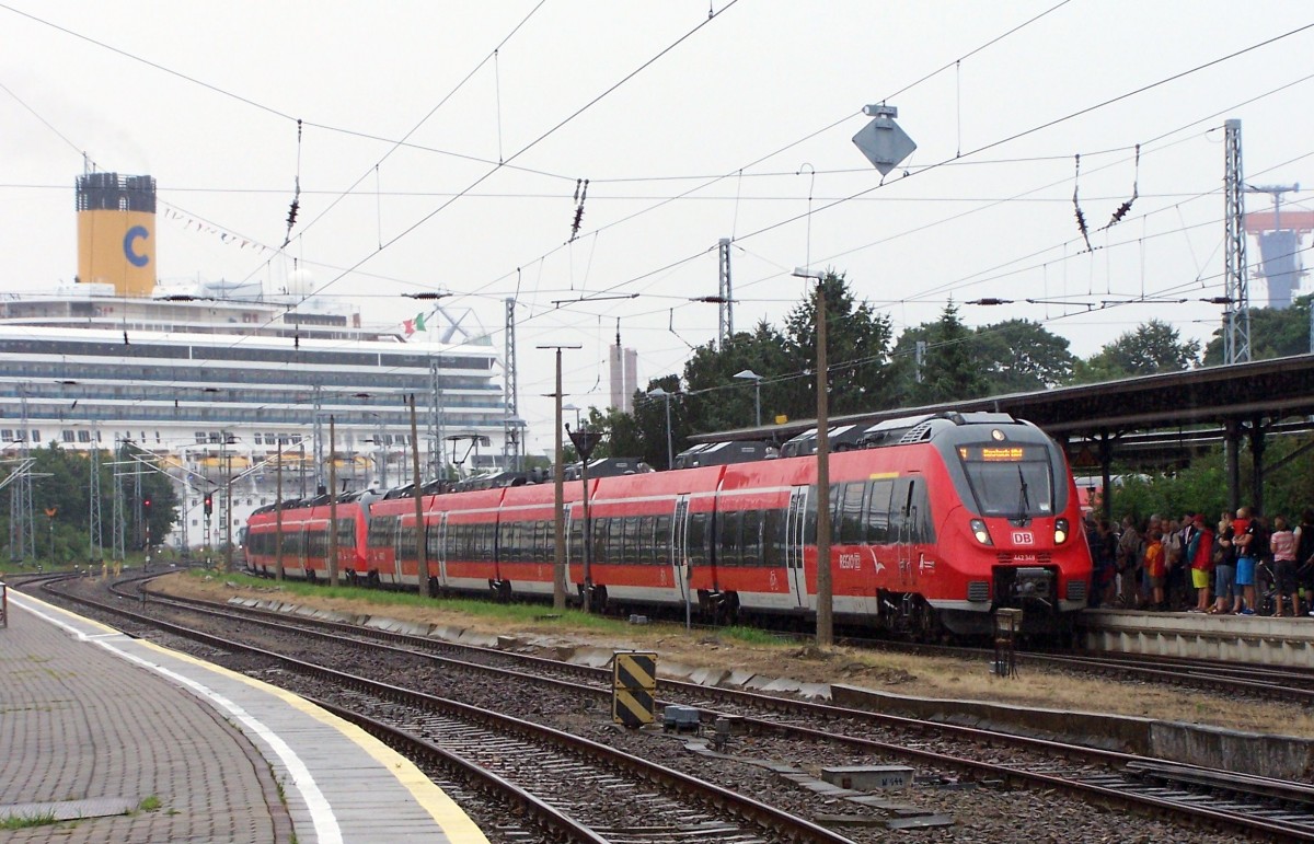 Warnemünde an der Ostsee ist einer der ganz wenigen Orte, wo man solche Fotos schießen kann: Zur Hansesail am 9.8.14 fuhr 442 348 in Doppeltraktion mit einem weiteren 5-teiler in Warnemünde ein, während im Hintergrund gerade die  Costa Fortuna  beim Festmachen war. Trotz zeitweilig strömendem Regen waren Tausende unterwegs und die Züge, die im 10-Minuten-Takt fuhren, stets voll.