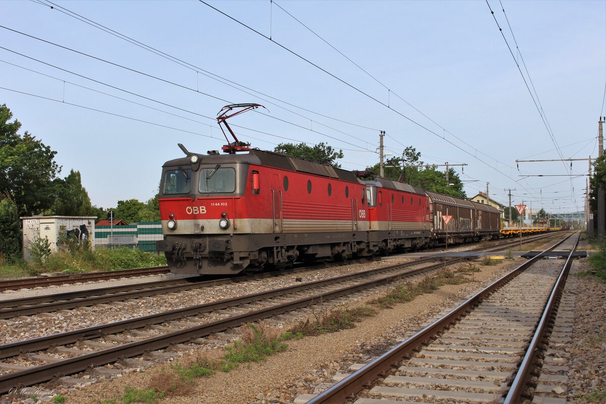 Warten im Bahnhof Oberlaa heißt bei langen Zügen immer, dass die Bahnhofs-EK  auf der die Segnerstraße die Donauländebahn kreuzt länger geschlossen ist.
So wie am 23.6.2023 als die 1144 102 und die 1144 278 mit dem DG54072 von Graz Vbf nach Wien Zvb hier auf die Weiterfahrt warten.