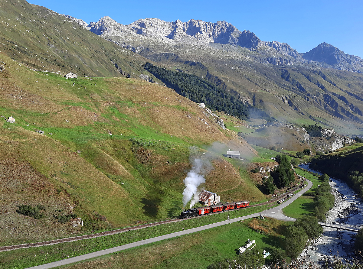 Was für eine Landschaft in den Schweizer Bergen! Dampfbahn-Fest (30 Jahre Wiedereröffnung der Strecke Realp - Furka sowie 40 Jahre Verein Furka-Bergstrecke VFB): Der Extrazug mit der Lok BFD 9 (Brig-Furka-Disentis) ist kurz nach der Abfahrt in Realp in den Zahnstangen-Bereich eingefahren und nimmt nun die 110 Promille-Steigung Richtung Furka in Angriff. Das Foto wurde von der anderen Talseite aus aufgenommen. Realp, 26.8.2023