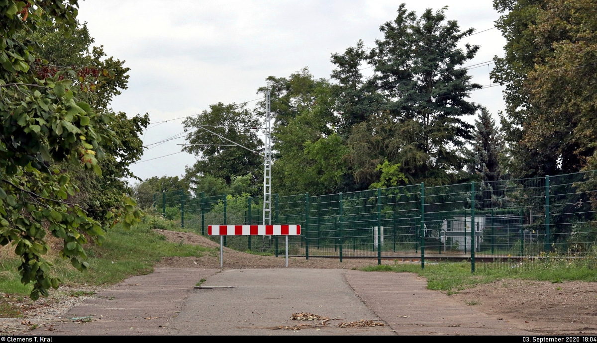 Weg ist sie, die Anrufschranke in Zscherben, Angersdorfer Straße - von der Bevölkerung auch  Klingelschranke  genannt. Das markante Klingeln des wärterbedienten Bahnübergangs ist nun endgültig verstummt.
Die Anlage wurde im Juli 2020 ersatzlos abgebaut und ein Zaun sowie breite Warnbaken installiert. In weniger als 100 Metern Entfernung befindet sich jedoch seit Längerem eine Eisenbahnunterführung (EU). Zuletzt wurde der Übergang noch sporadisch von Fußgängern genutzt, teils mit langen Wartezeiten.
(Smartphone-Aufnahme)

Hier ein Bild vom vorherigen Zustand:
https://www.bahnbilder.de/bild/Deutschland~Bahntechnische+Anlagen+und+Kunstbauten~Bahnubergange/1152452/fruehlingshafter-blick-auf-den-bue-zscherben.html

🚩 Bahnstrecke Halle–Hann. Münden (KBS 590)
🕓 3.9.2020 | 18:04 Uhr