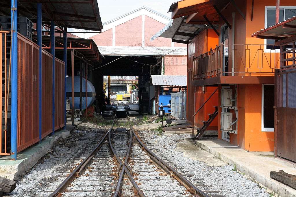 Wegen der Bauarbeiten für den westlichen Teil (Thailand Cultural Centre - Bang Khun Non, 13,4 Km) der MRT Orange Line (Yaek Rom Klao - Bang Khun Non, 35,9 Km) mussten in der Thon Buri Station und auch im Depot umfangreiche Änderungen an der Gleisgeometrie vorgenommen werden. - Da das Wendegleis der neu errichtete östliche Depotzufahrt für 2-teilige Triebwagen zu kurz ist wurde eine neue Zufahrt errichtet und die Triebwagen müssen nun durch die Lokhalle fahren. - Im Bild vom 28.Mai 2025 die Weiche im Depot zur Station.