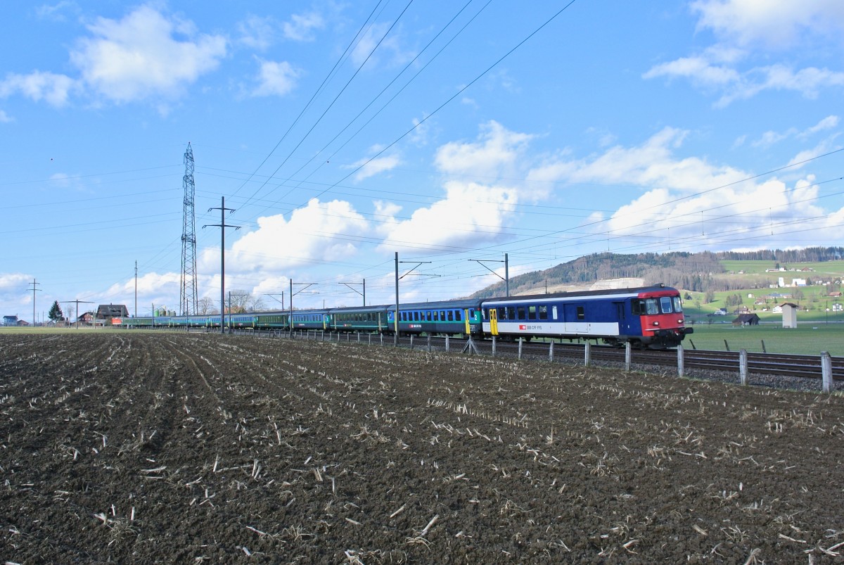 Wegen der Grossreinigung am planmässigen Pendel verkehrte heute als IC 571/578 Zürich-Chur-Zürich ein langer EWI/II Pendel. Beim Pendel handelt es sich um einen in Zürich stationierten Reservependel, welcher für solche geplanten Ersatzleistungen verwendet wird. Im Bild ist der Pendel als IC 571 bei Siebnen-Wangen. An der Spitze ist der BDt EWI 50 85 82-33 976-0, 11 EWI/II Wagen (4 davon 1. Klasse) schiebt die Re 4/4 II 11124, 12.02.2014. Leider kam genau während der Durchfahrt dieses Zuges eine Wolke vor die Sonne..