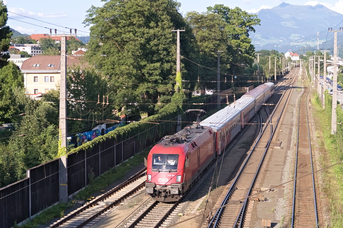 Wegen Neubau der Vomperbachbrücke verkehrt der Regional-Express zwischen Jenbach und Hall i. T. ohne Halt über die neue Unterinntalbahn (Tunnelstrecke), weshalb ETCS-fähige Fahrzeuge nötig sind. Statt der sonst üblichen BR 4024 verkehrt 1116.169 mit gemischten Nah- und Fernverkehrswaggons, hier bei der Einfahrt zum Bahnhof Hall i. T. Diesem Kurs als baustellenbedingtem Sonderverkehr wurde die Nummer REX35228 zugewiesen. Aufgenommen 14.8.2019.