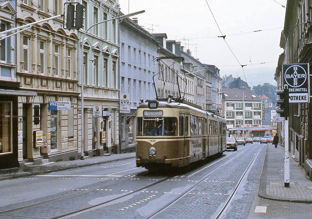 Wegen der unsicheren Zukunft der Straßenbahn verzichteten die Wuppertaler Stadtwerke auf die Neubeschaffung von Achtachsern und kauften stattdessen neun Dortmunder Zweirichtungstriebwagen, die unter den Nummern 3823-3831 eingereiht wurden. Noch in der Dortmunder Farbgebung ist Tw 3828 um 1984 in der Rudolfstraße auf der am 15.06.1985 eingestellten Linie 608 zum Klinikum Barmen unterwegs. 