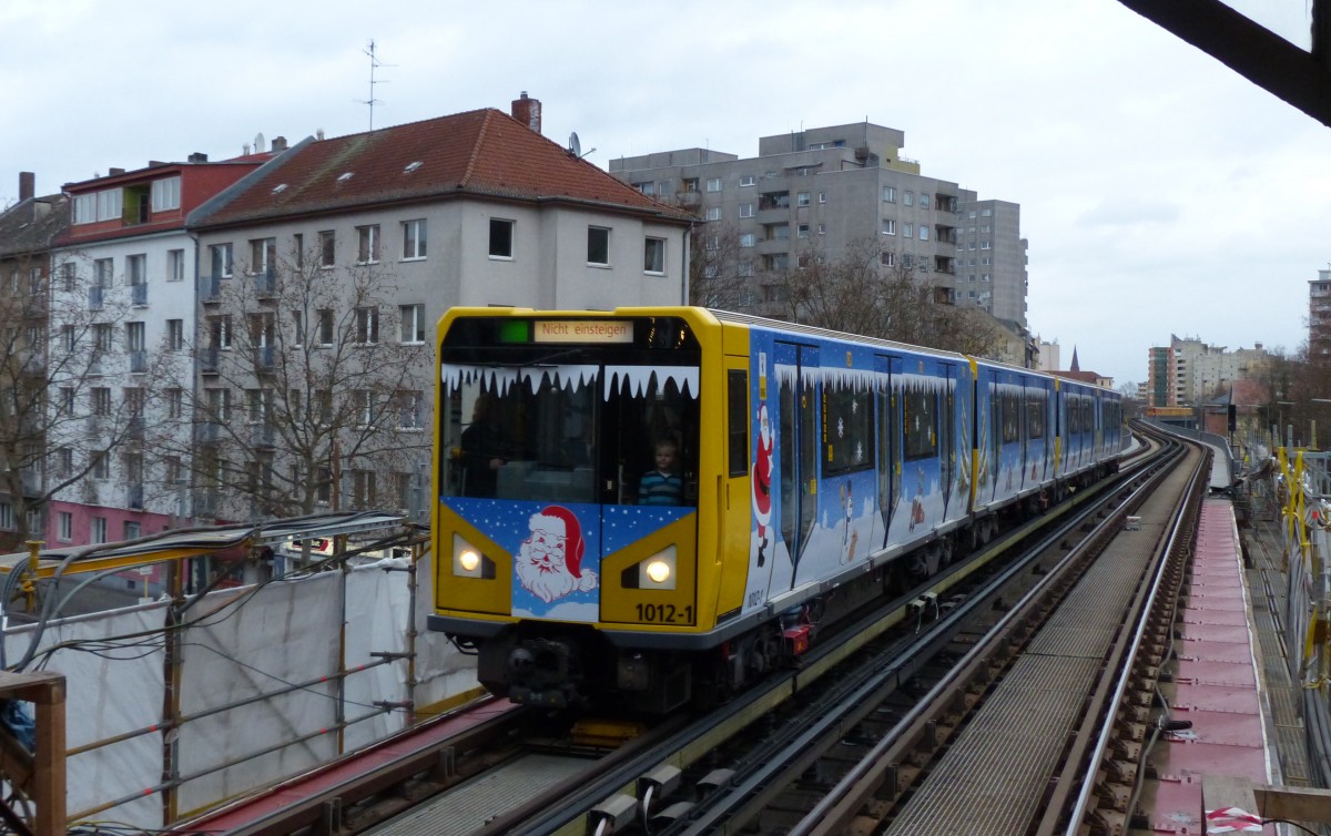 Weihnachtszug der Berliner U-Bahn am 20.12.2014 am Bahnhof Prinzenstraße. Hier fuhr der Weihnachtsmann mit, die Kinder waren begeistert. Für ganz aufmerksame Kinder hält auch der Bahnhof Prinzenstraße eine märchenhafte Überraschung parat: In einer Ecke sitzt ein kleiner Froschkönig auf der goldenen Kugel. Na, wenn der Weihnachtsmann das wüsste ... Leider war dieses Foto nur ein Notschuss. Ich wusste, dass der Zug gleich kommen würde, und wollte nur die Seite wechseln, habe aber nicht mit der zeitlichen Unendlichkeit von Fußgängerampeln gerechnet - somit war mir ein Motiv wie dieses nicht mehr möglich: http://www.bahnbilder.de/bild/deutschland~stadtbahnen-und-u-bahnen~u-bahn-berlin-historische-wagen-und-u-bahn-museum/670718/historischer-ai-zug-mit-4-wagen-vor.html

20.12.2014, Prinzenstraße